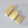 A stack of metallic gold dessert cake boards shown from an angle on a light gray surface.