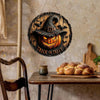 Panneau de décoration d'Halloween en bois rond avec une citrouille sculptée et un chapeau de sorcière sur fond rustique.