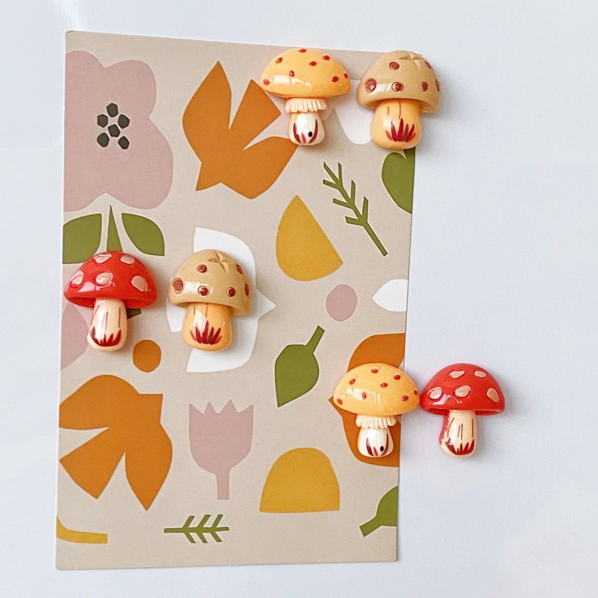 A set of nine cute decorative mushroom fridge magnets featuring various colors and shapes on a light background.