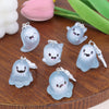 A collection of light blue ghost-shaped glow-in-the-dark keychains resting on a wooden surface.