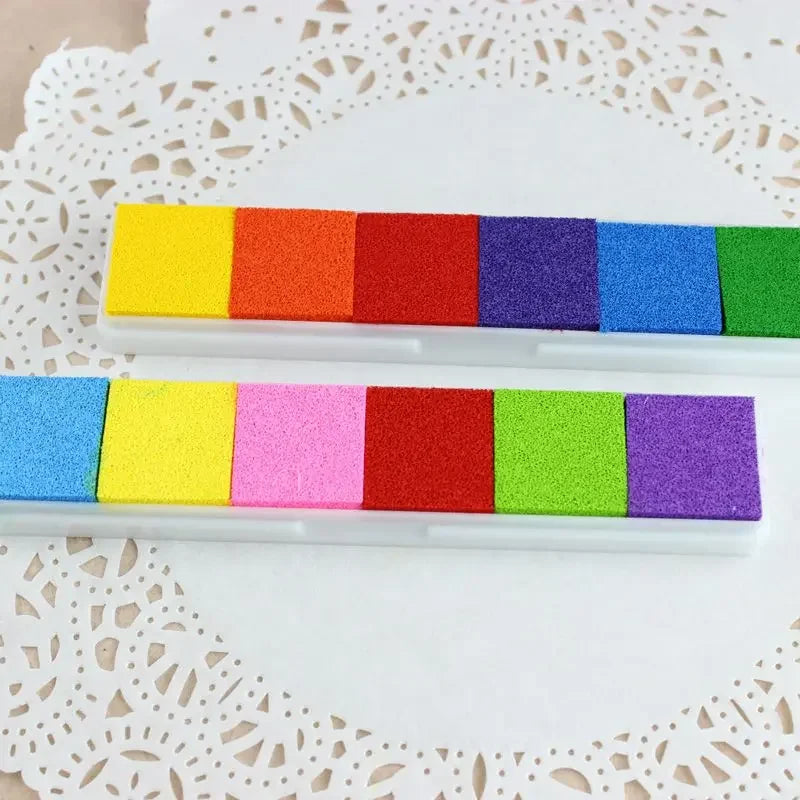 Une rangée de tirages sur toile carrés et empreintes à l'encre colorés sur fond blanc.