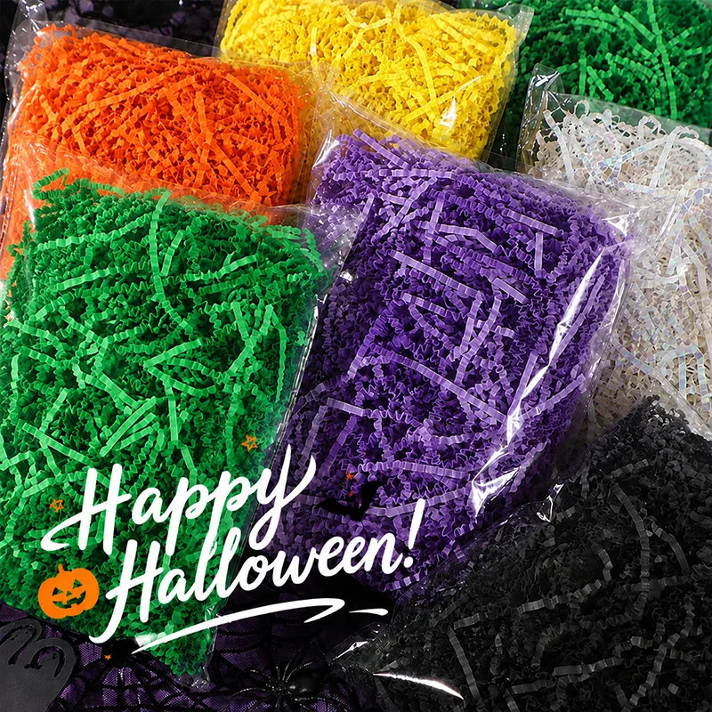 A collection of brightly colored crinkle paper shred filler in orange, yellow, green, and purple for Halloween decorations.