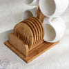 A set of white ceramic coffee mugs displayed on a natural bamboo wood stand.