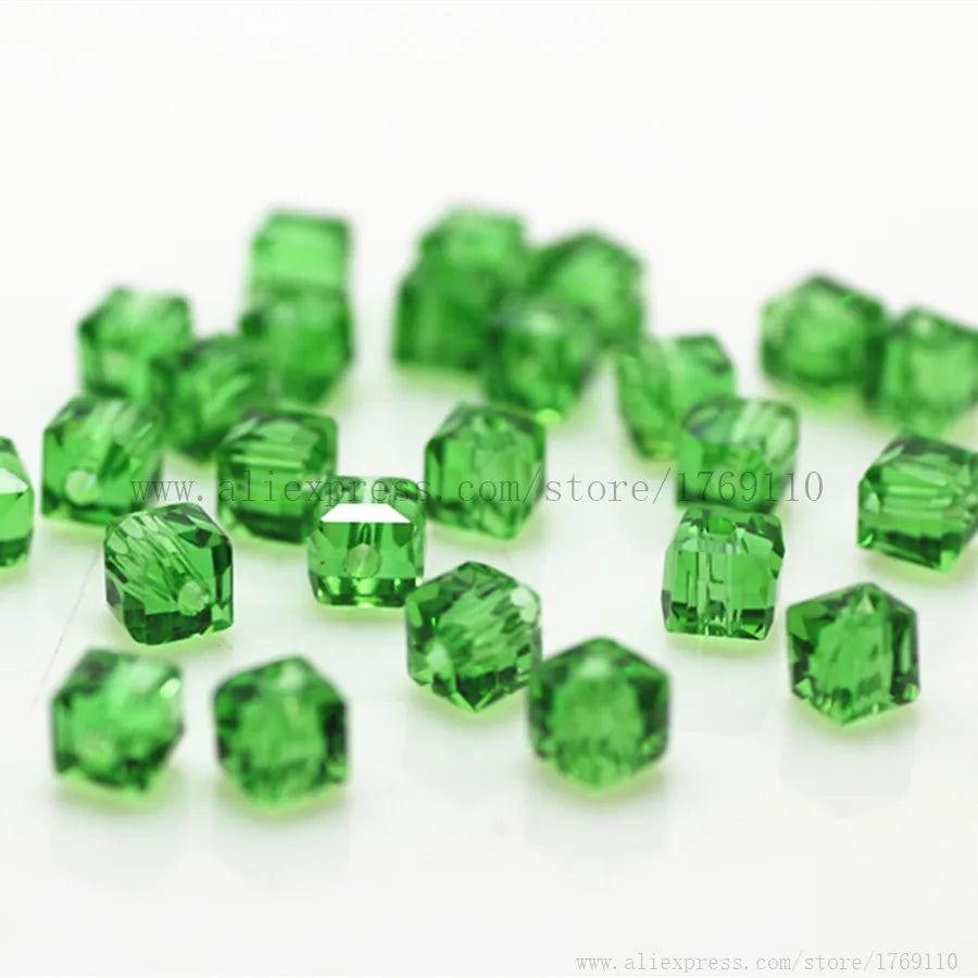 Green square cut glass crystal beads scattered on a white background for jewelry making