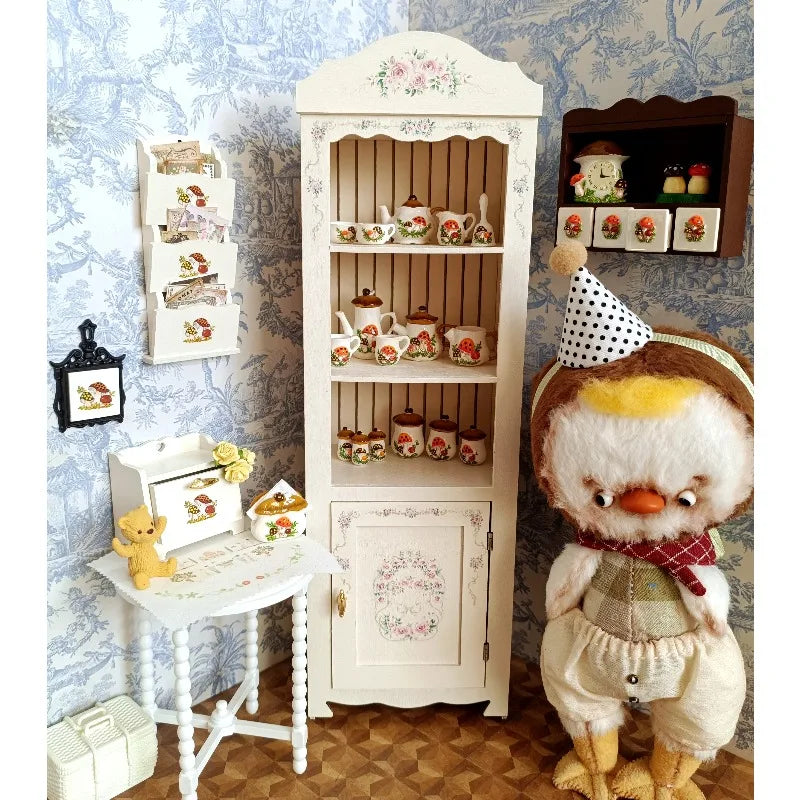 A handcrafted miniature mushroom tableware set displayed next to a dollhouse cabinet and a plush toy.