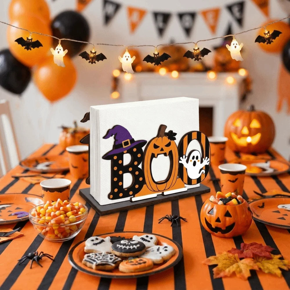 A Halloween display featuring pumpkins, bats, and a wooden tissue dispenser with black and orange lettering.