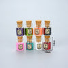 A collection of eight glass jars filled with glitter powder in various colors and labeled Magic