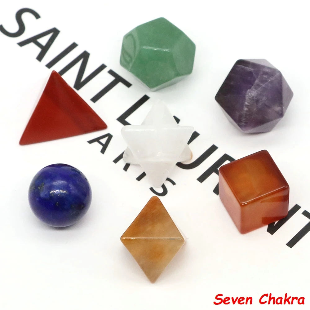A collection of seven colored crystals including green, purple, red, white, blue, and amber stones.