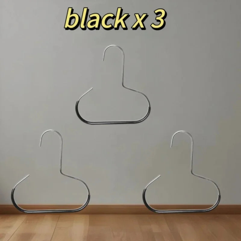 Three black metal hat organizer racks hanging on a white wall.