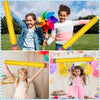 Dos niños sosteniendo lápices amarillos inflables gigantes y globos para decoración escolar o de graduación