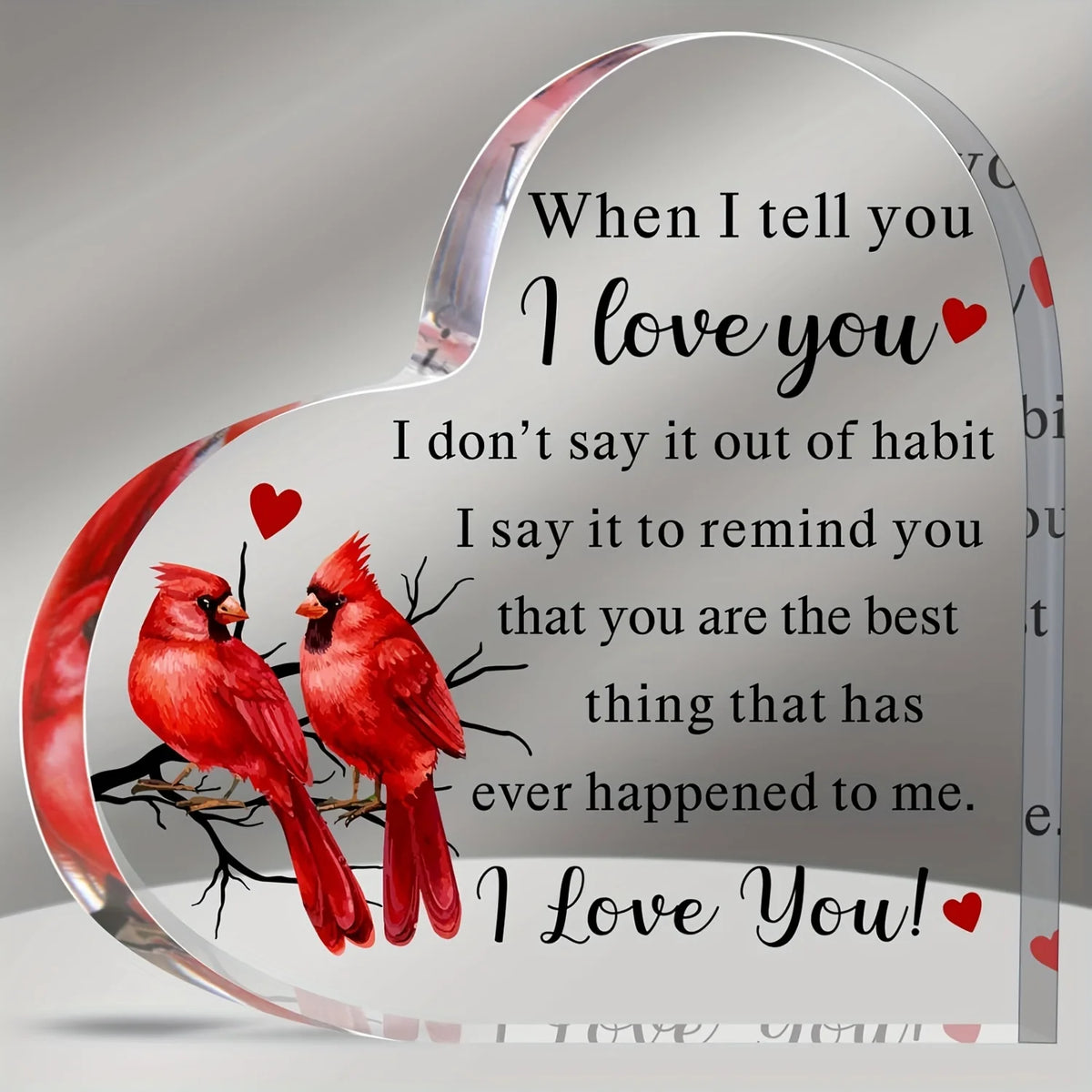 A clear acrylic heart-shaped keepsake engraved with the message I love you and a red bird.