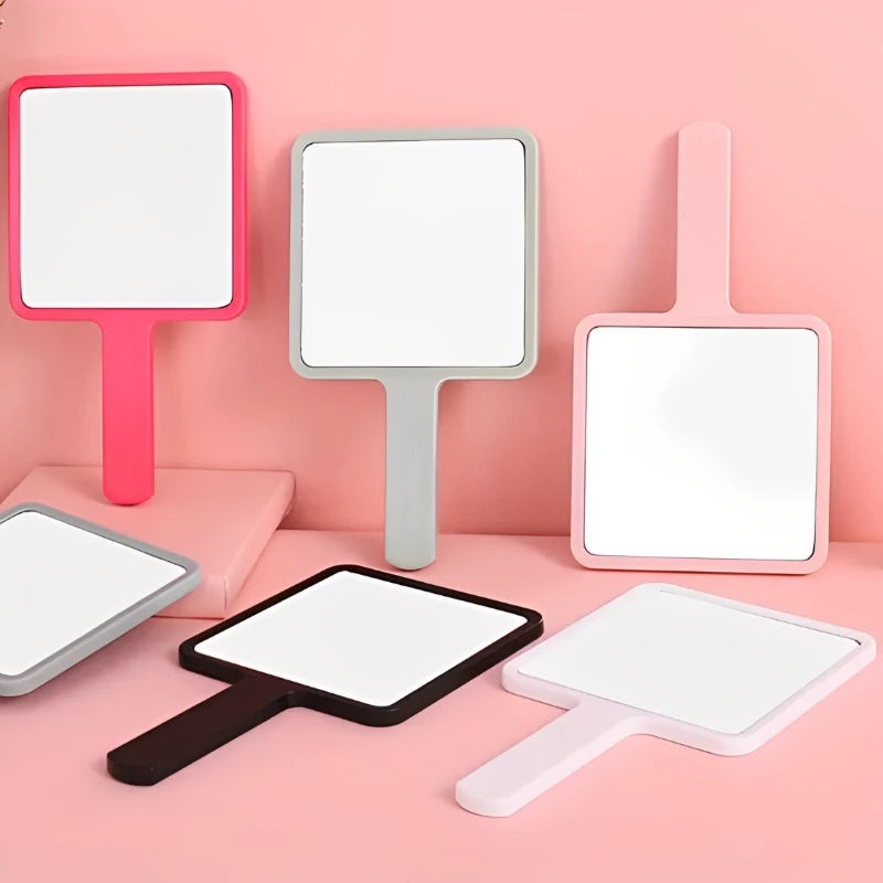 Pink and gray handheld vanity mirrors displayed on a pink background.