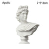 A white plaster bust miniature of Apollo, a classic Greek mythology figure.
