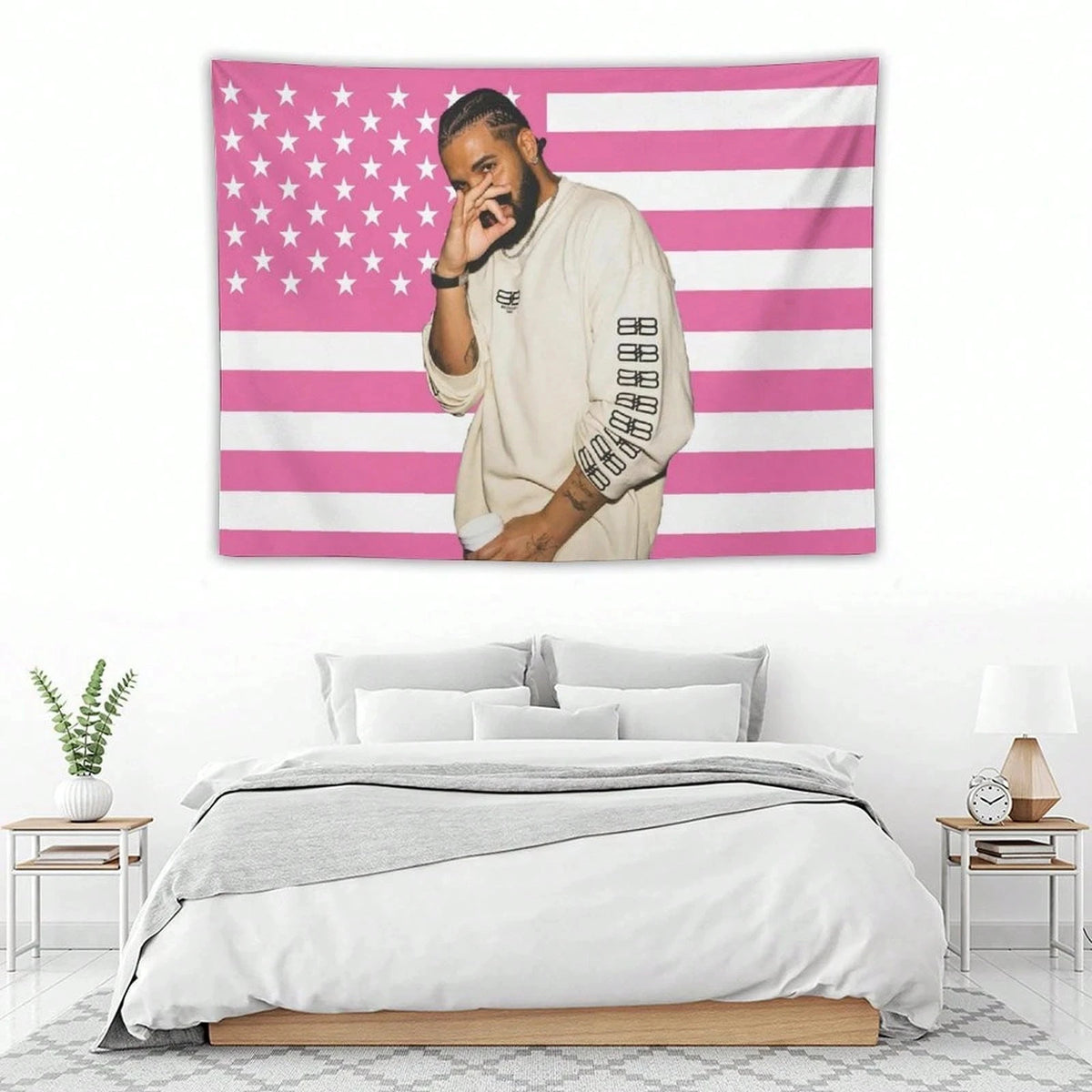 Un homme en chemise claire devant un mur décoratif d'une tapisserie avec un drapeau américain rayé rose et blanc.