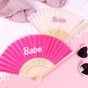 Pink and gold hand fans labeled Bride and Babe displayed on a pink background.
