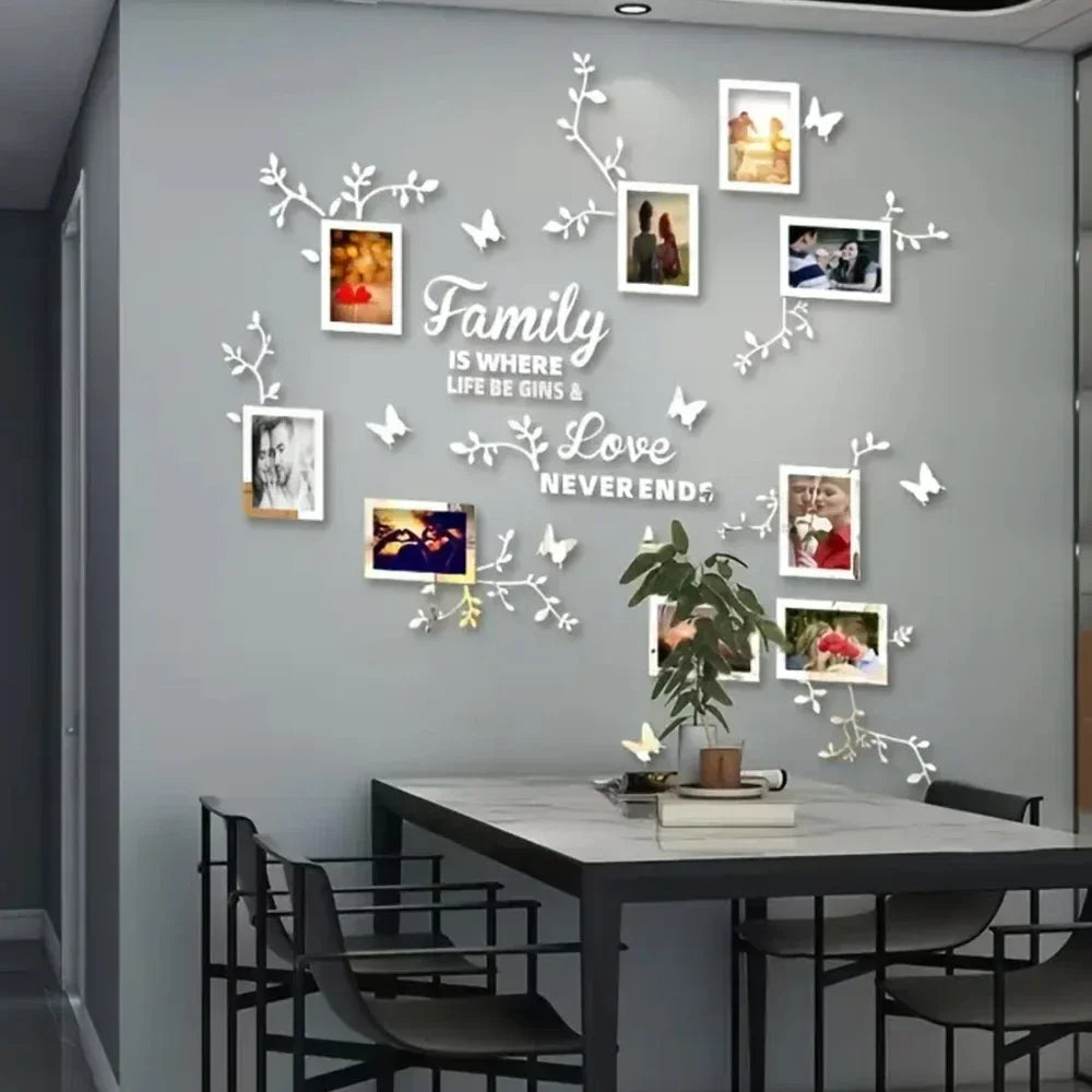A gray wall decorated with a white floral vine design and several framed photos, featuring the text Family is where life be g