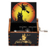 A carved wooden music box featuring a Halloween-themed design with a bat-winged witch silhouette against an orange moon.