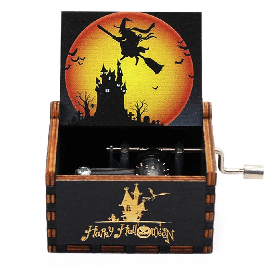 A carved wooden music box featuring a Halloween-themed design with a bat-winged witch silhouette against an orange moon.