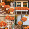 A collection of bright orange and yellow artificial pansy flowers in various pots and hanging arrangements.