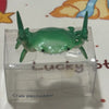 A green crab-shaped desk organizer with a pen holder is displayed in its clear plastic packaging.