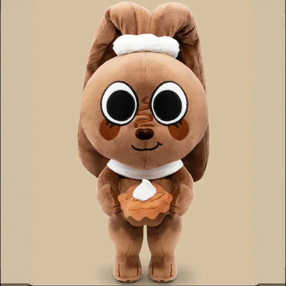 A brown plush doll resembling a dandy butterfly with white accents and an orange food item.