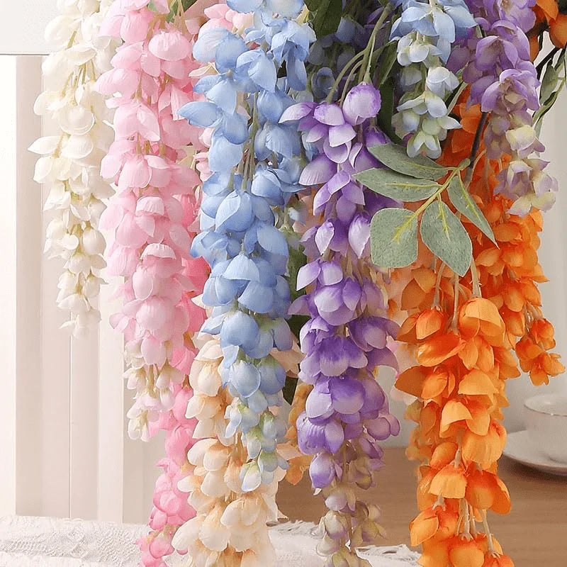 A cascade of artificial wisteria hanging vine featuring silk blooms in shades of purple, blue, pink, and orange.