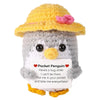 A handcrafted crochet penguin doll with a yellow hat and a message card that reads Here's a hug while I can't be there Put me