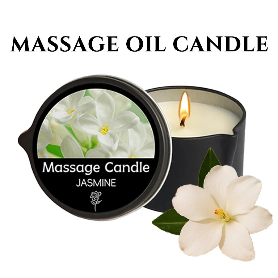 A black jar of Jasmine massage candle with a lit wick and a white jasmine flower nearby.