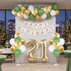 A backdrop featuring a green and gold balloon arch and banner for a birthday celebration.