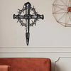 Black metal cross wall art featuring thorns and a pointed design on a white wall.