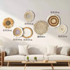 A collection of round boho straw wall hangings in various sizes and shades of natural beige and white.
