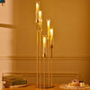 A set of five gold LED candle holders standing on a wooden surface with decorative elements.