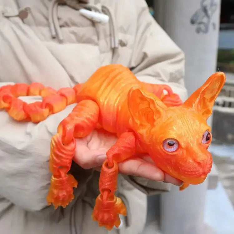 An orange realistic Sphynx cat fidget toy is held in a person's hand.