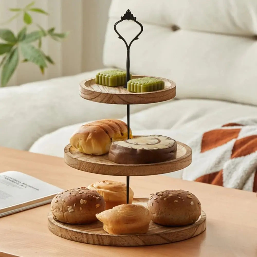 A wooden 3-tier cupcake stand with detachable layers displaying baked goods on a light surface.