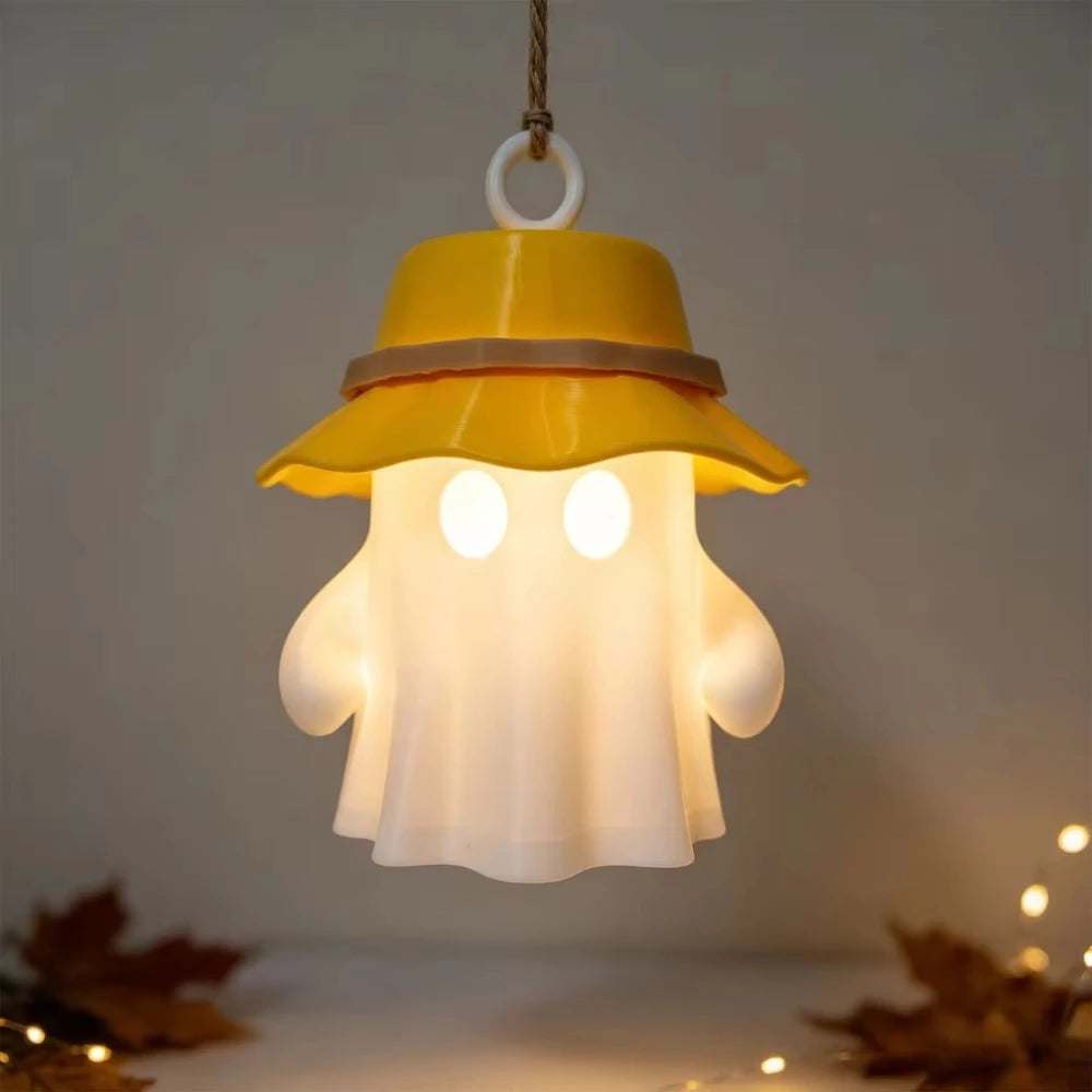 A yellow camping ghost night light hangs, featuring a glowing white face and a brimmed hat.