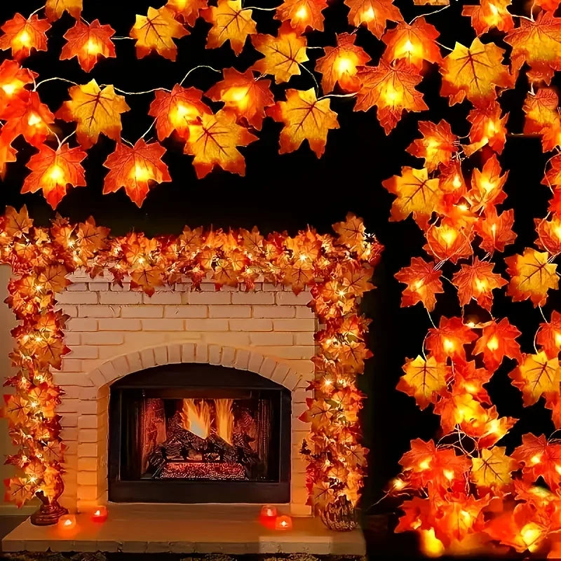 A display of orange and yellow maple leaf LED string lights forming a garland over a white fireplace mantel.