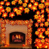 A display of orange and yellow maple leaf LED string lights forming a garland over a white fireplace mantel.