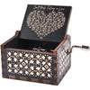 An antique engraved wooden music box with a lid featuring a poem about falling in love