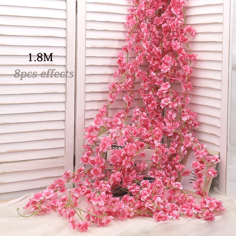 A cascade of pink artificial sakura flower garland draped against a white slatted background.