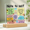 An acrylic desk sign with a note to self featuring positive affirmations like being important and allowing oneself to try aga