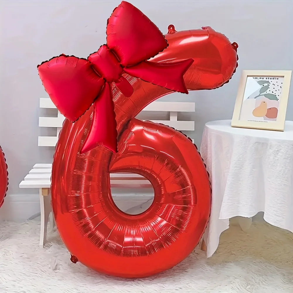 A large red foil number balloon shaped like the number 6, tied with a matching red bow.