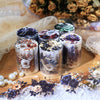 Rolls of floral PET stickers in various colors and patterns displayed on a wooden surface with lace