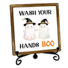 A framed sign with text that reads Wash Your Hands Boo featuring two white ghost figures.