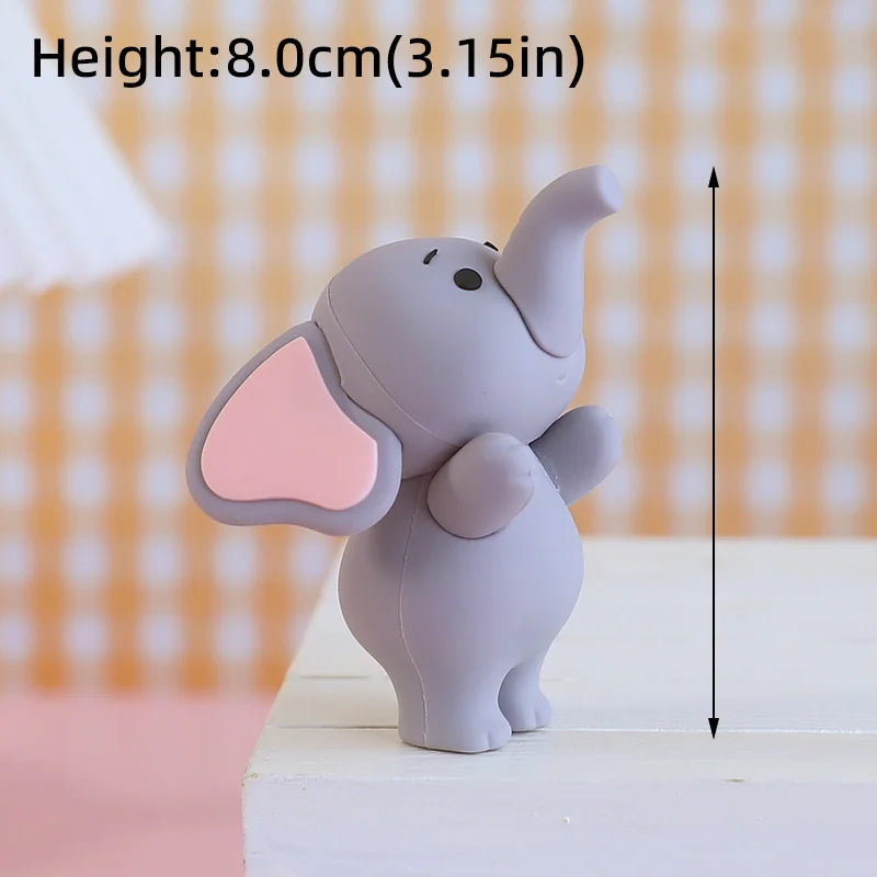 A small gray cartoon elephant figure with pink ears standing on a white surface.