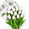 A bouquet of white and pink artificial tulips with green stems displayed on a white background.
