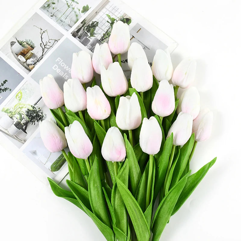 A bouquet of white and pink artificial tulips with green stems displayed on a white background.