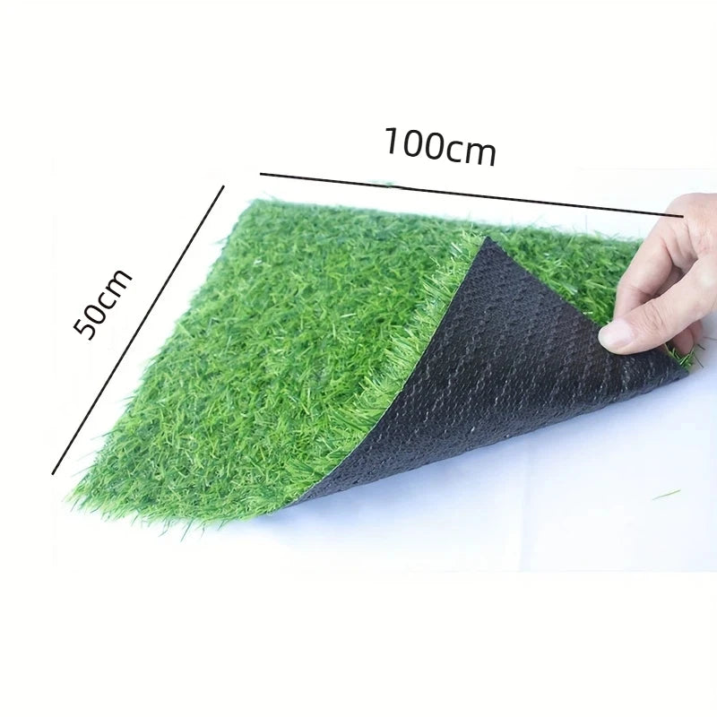 Ein rechteckiges Stück grünes Kunstgras, 100 cm lang und 50 cm hoch, wird von einer Hand gehalten.