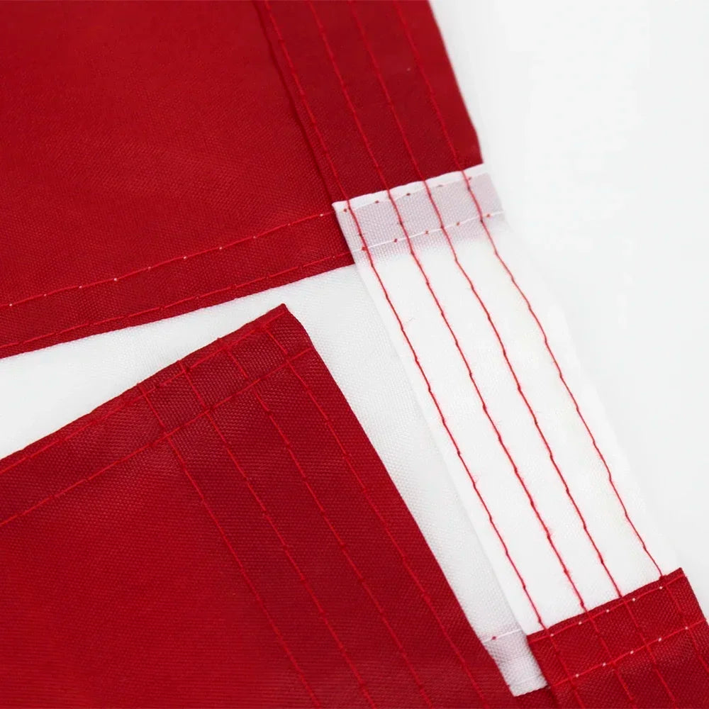 Close-up of a red heavy duty embroidered American flag banner with white trim and stitching.