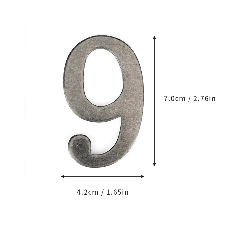 A silver magnetic house number shaped like the numeral 9, measuring 7.0cm long.