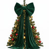 A green Christmas tree decorated with red ornaments and topped by a large velvet bow with long streamers.